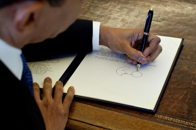 Obama signing a document