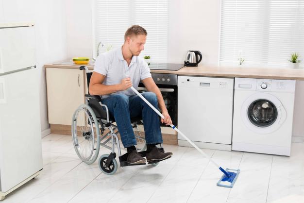 Man in wheelchair mopping the floor