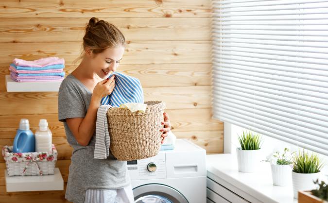 Woman smelling basket of clean laundry