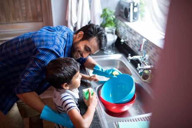 father and child doing dishes
