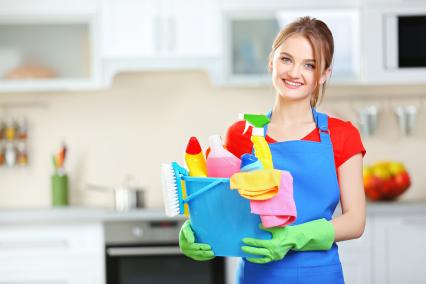 A woman holding a basket of cleaning products