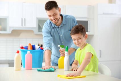 Father and sun cleaning the kitchen counter together