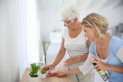 Woman helping senior clean the house