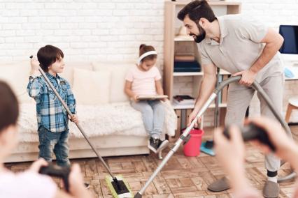 Father cleaning the house with his kids