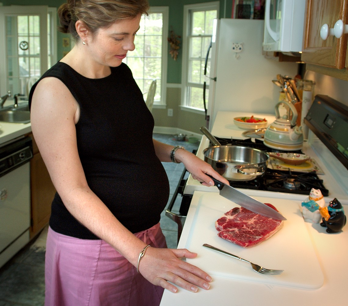 pregnant woman cutting board steak