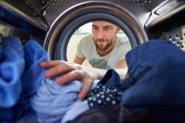 Man reaching into dryer for clothes