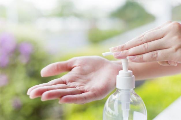 woman using hand sanitizer