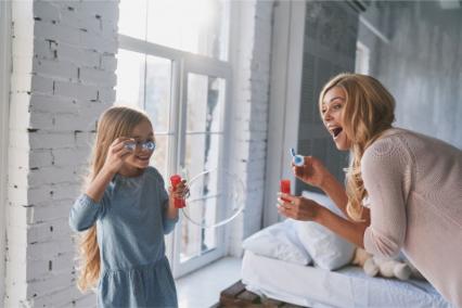 Mom and daughter blowing bubbles together